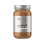 Jar of ripe bone broth with a silver lid on a white background